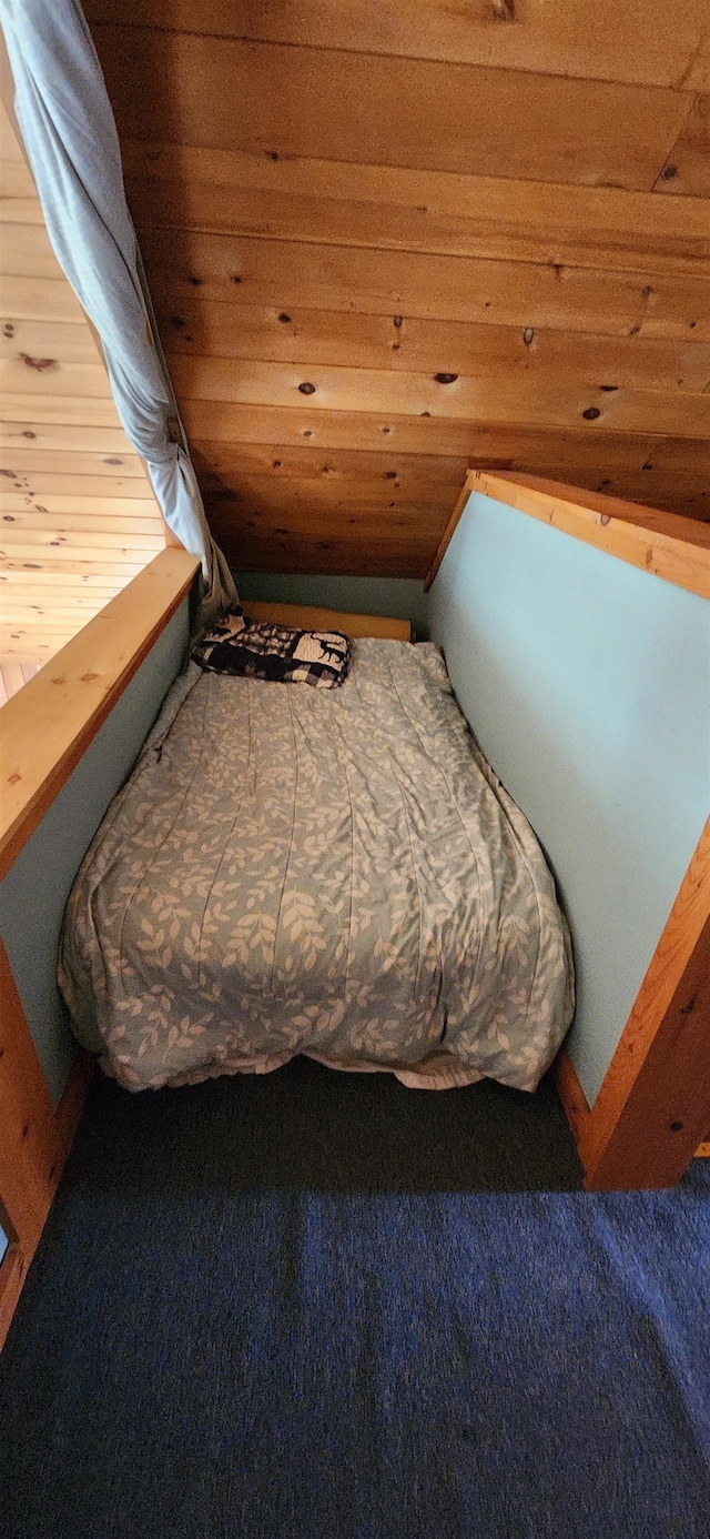 bedroom featuring wood ceiling, wood walls, and carpet floors