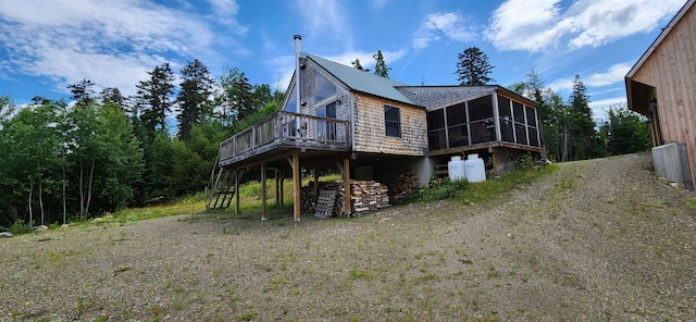 view of home's exterior featuring a sunroom and a deck