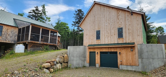 exterior space with a garage and a sunroom