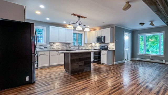 kitchen with a kitchen island, dark hardwood / wood-style flooring, a baseboard radiator, hanging light fixtures, and stainless steel appliances