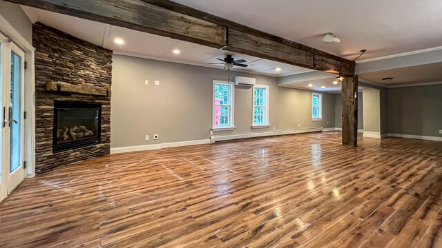 unfurnished living room with a fireplace, hardwood / wood-style flooring, a wall mounted AC, and a baseboard radiator