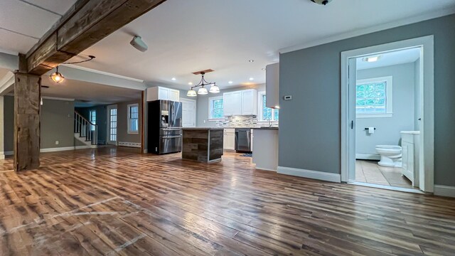 kitchen featuring a center island, stainless steel appliances, a chandelier, white cabinetry, and wood-type flooring