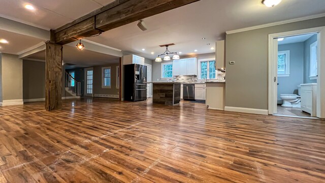 interior space with baseboard heating, dark hardwood / wood-style flooring, a notable chandelier, beamed ceiling, and ornamental molding