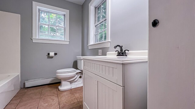 bathroom featuring toilet, tile patterned floors, vanity, baseboard heating, and a bathtub