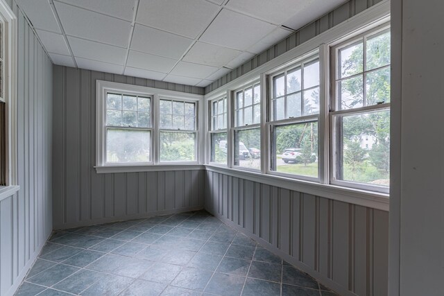 unfurnished sunroom with a wealth of natural light and a drop ceiling