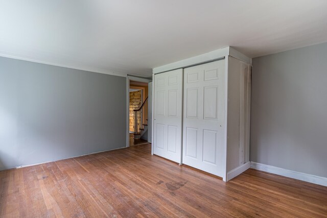 unfurnished bedroom with hardwood / wood-style floors and a closet