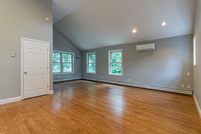 unfurnished living room featuring a wall mounted AC, light wood-type flooring, high vaulted ceiling, and a baseboard radiator