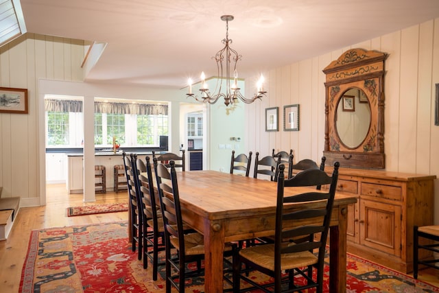 dining space with light wood-type flooring and a notable chandelier