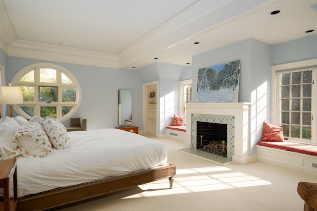 bedroom with crown molding, carpet, and a tile fireplace