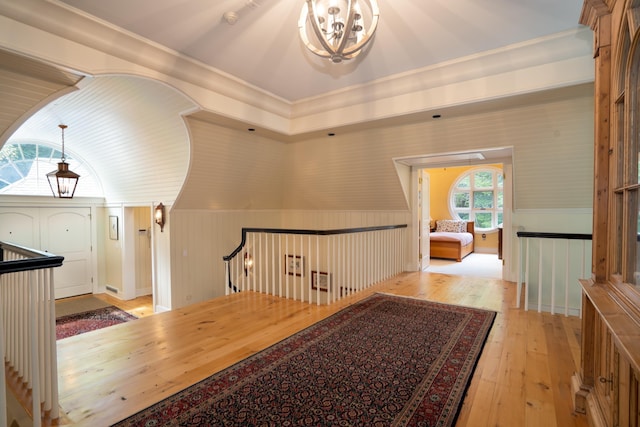 additional living space featuring light wood finished floors and an inviting chandelier