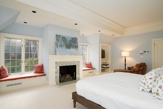 bedroom featuring visible vents, vaulted ceiling, carpet flooring, and a tiled fireplace