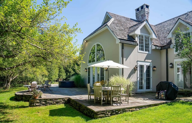 back of house featuring french doors, a patio, a yard, and a chimney