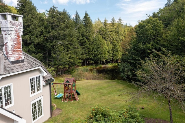 view of yard featuring a view of trees and a playground