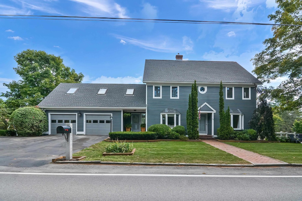 colonial home featuring a garage and a front lawn