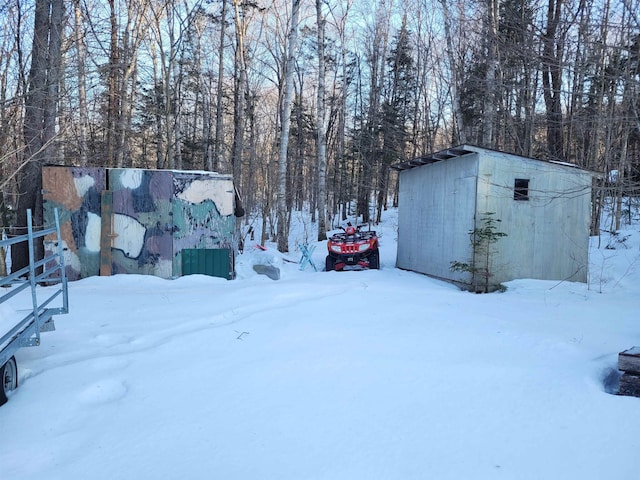 yard layered in snow with a storage unit