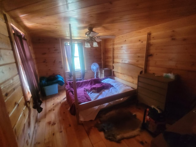 bedroom featuring ceiling fan, hardwood / wood-style flooring, wood walls, and wooden ceiling