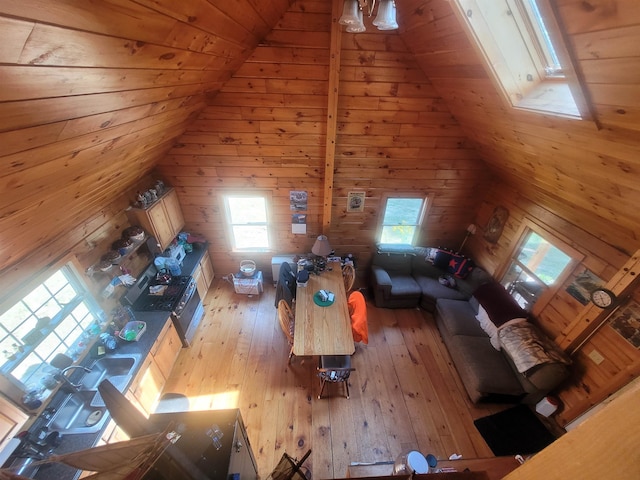 unfurnished living room featuring wood ceiling, light hardwood / wood-style floors, wood walls, and lofted ceiling