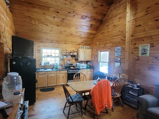 dining room featuring wooden walls, lofted ceiling, and plenty of natural light