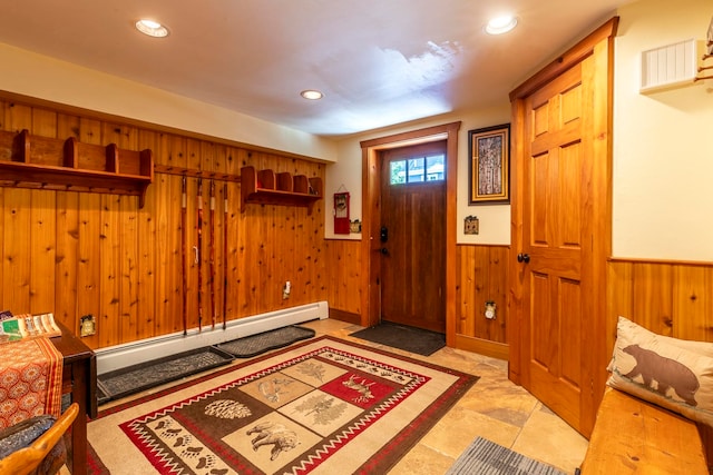 entrance foyer with wood walls and a baseboard heating unit