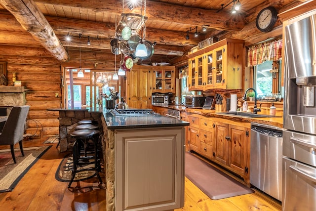 kitchen featuring a kitchen island, a breakfast bar area, light hardwood / wood-style flooring, stainless steel appliances, and sink