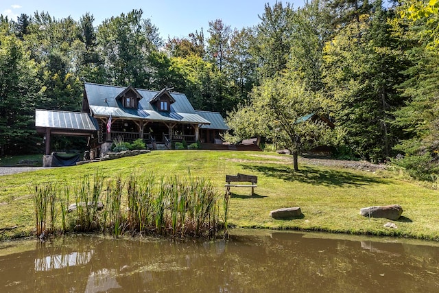 exterior space with a water view and a lawn