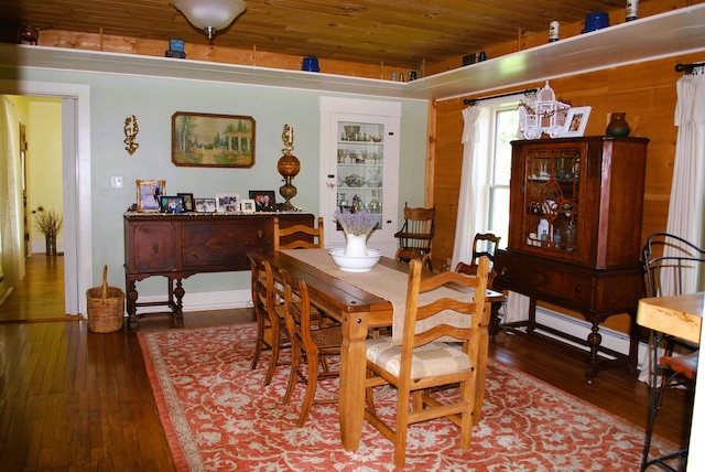 dining area featuring a baseboard radiator, hardwood / wood-style flooring, and wooden ceiling