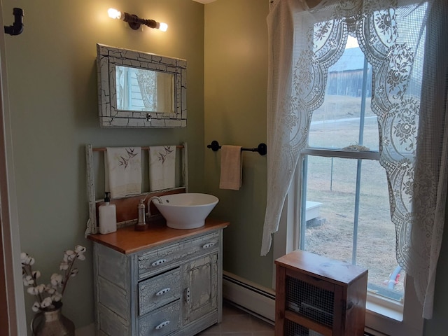 bathroom featuring a baseboard heating unit, vanity, a wealth of natural light, and tile patterned floors