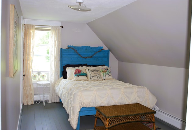 bedroom featuring a baseboard heating unit, vaulted ceiling, and dark hardwood / wood-style flooring