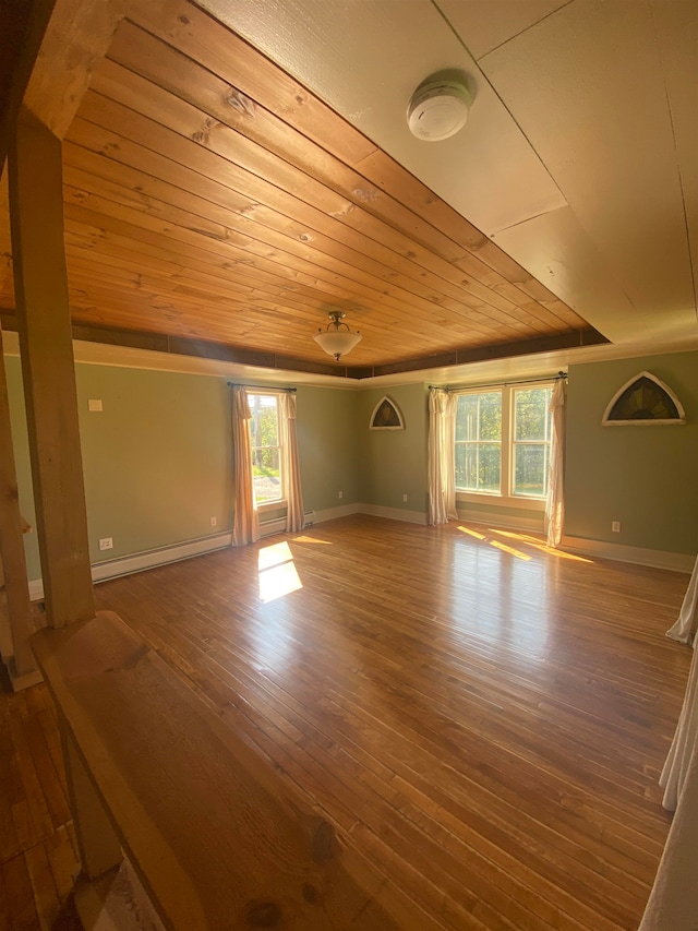 additional living space with a baseboard heating unit, hardwood / wood-style flooring, plenty of natural light, and wooden ceiling