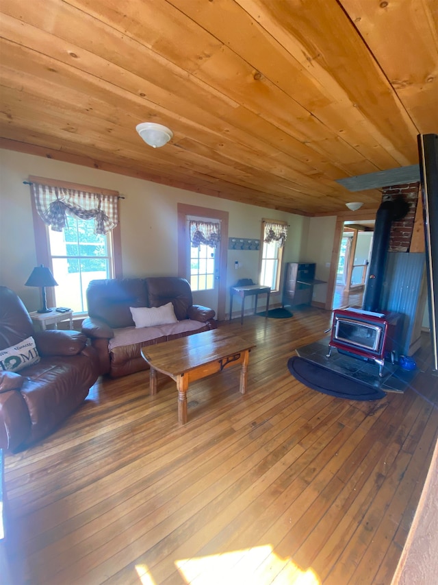 living room with a wood stove, hardwood / wood-style floors, and wood ceiling