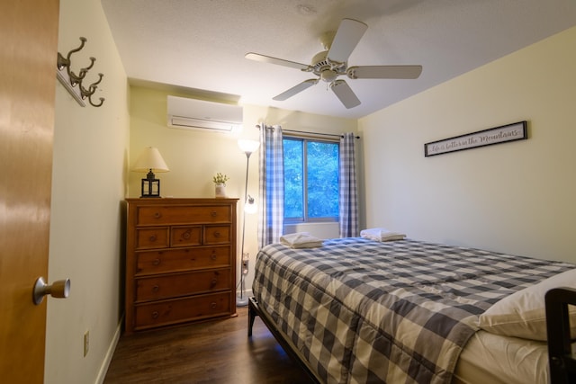 bedroom with a wall unit AC, a ceiling fan, dark wood-style flooring, and baseboards