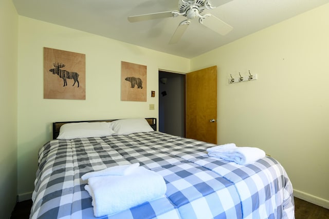 bedroom with wood finished floors, a ceiling fan, and baseboards