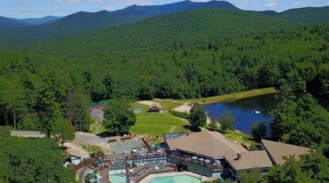 aerial view with a wooded view and a water and mountain view