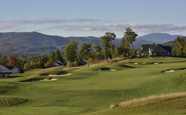 surrounding community featuring a mountain view, a yard, and view of golf course