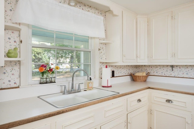 kitchen featuring white cabinetry and sink