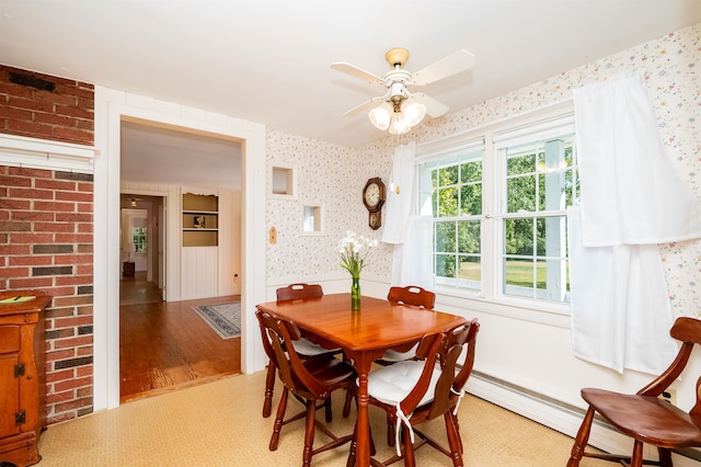 dining room with a baseboard heating unit, ceiling fan, and light wood-type flooring