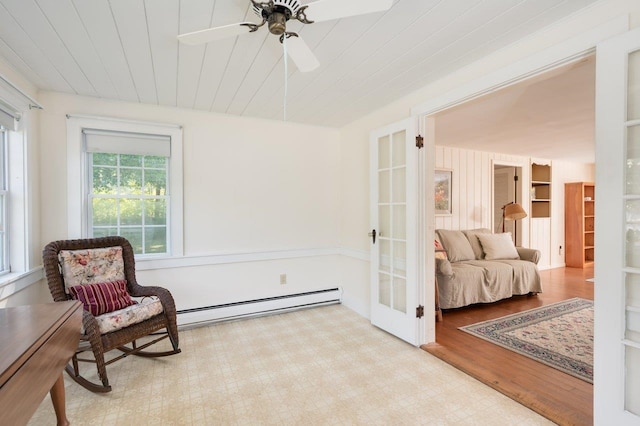 sitting room with ceiling fan, baseboard heating, wooden ceiling, and light hardwood / wood-style flooring