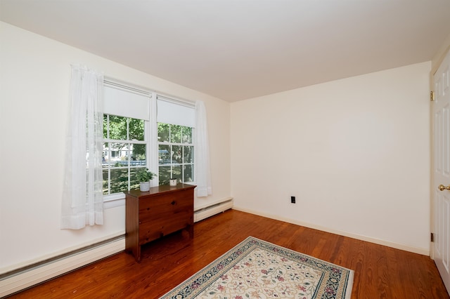 spare room with a baseboard heating unit and hardwood / wood-style flooring