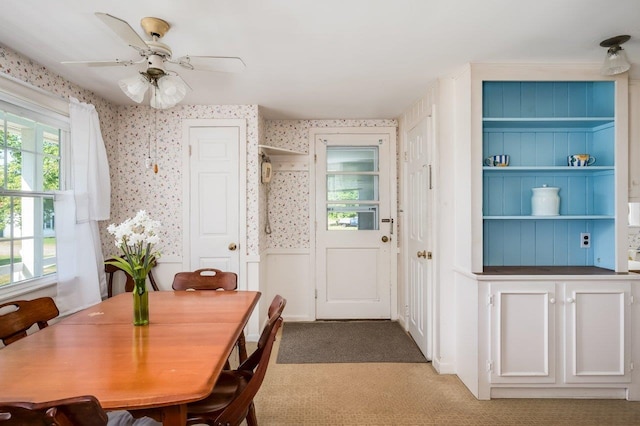 carpeted dining space with ceiling fan