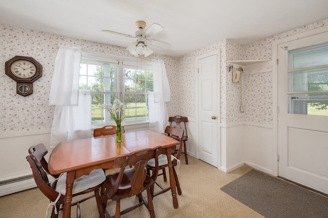 dining room with ceiling fan, baseboard heating, and light carpet