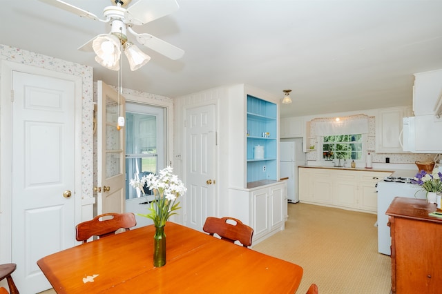 dining area with ceiling fan and sink