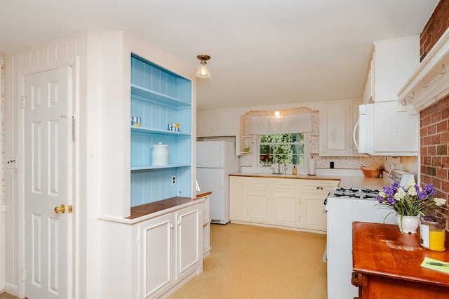 kitchen with light carpet, white appliances, sink, and white cabinets