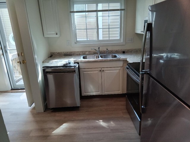 kitchen featuring light wood-type flooring, white cabinetry, plenty of natural light, and stainless steel appliances