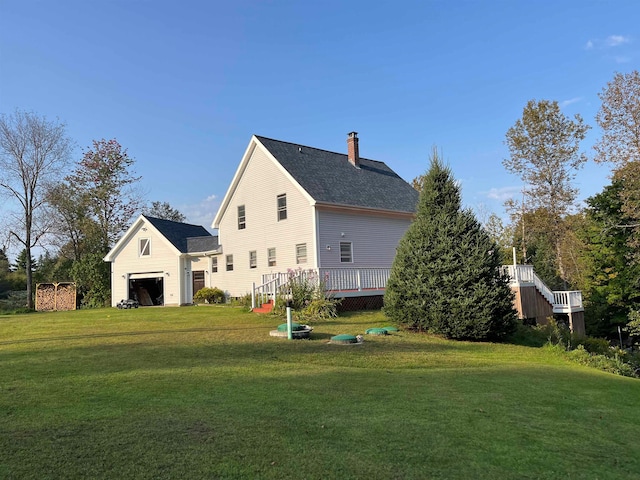 back of house with roof with shingles, a yard, a chimney, and a wooden deck