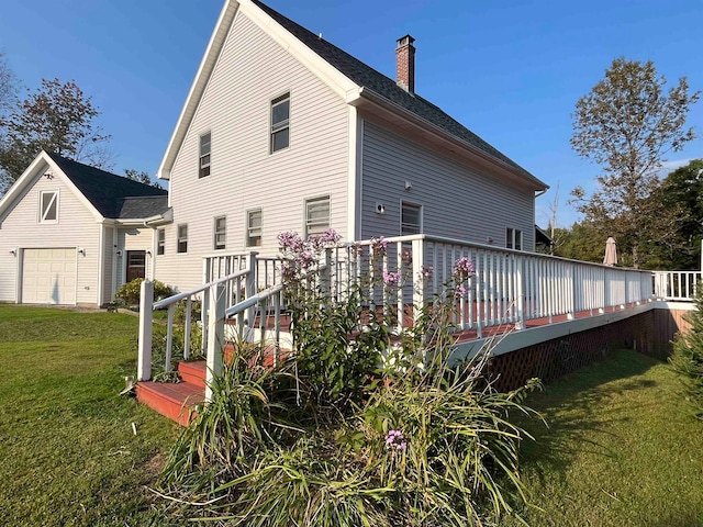 back of house featuring a yard, a chimney, and a wooden deck