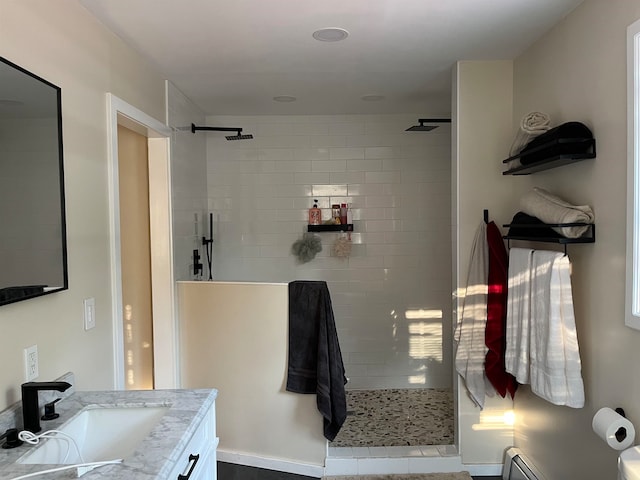 full bathroom featuring a baseboard radiator, vanity, and a walk in shower