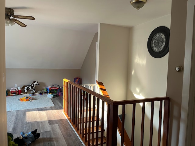 interior space featuring lofted ceiling, wood finished floors, and an upstairs landing