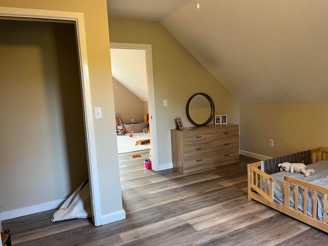 bedroom with baseboards, vaulted ceiling, and wood finished floors