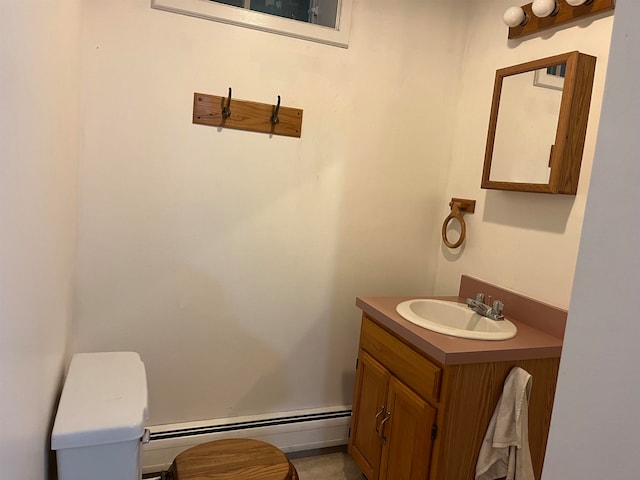 half bathroom with toilet, baseboard heating, and vanity