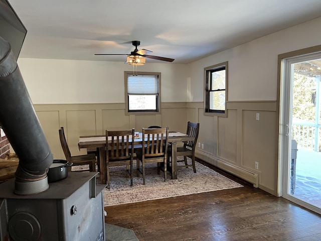 dining area featuring wainscoting, dark wood-type flooring, and plenty of natural light